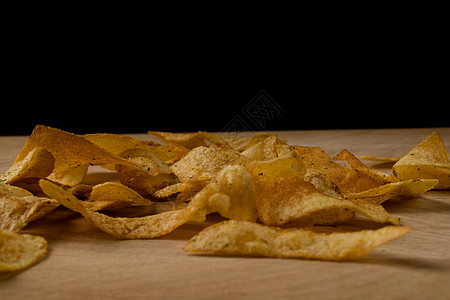 分散在木板上的开胃薯片脆薯片食物营养宏观金子食欲芯片小吃筹码味道盐渍图片