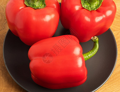 木板上黑色盘子里的三片甜辣椒营养红色美食蔬菜食物团体小吃白色绿色作品图片