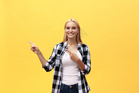 穿着T恤 笑着笑着看的年轻女人 用大拇指指向黄色背景头发成人幸福微笑白色黑发工作室学生女孩快乐图片