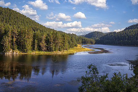湖边的轻松的山地景观 充满平静的水 树木倒影和美景天空图片