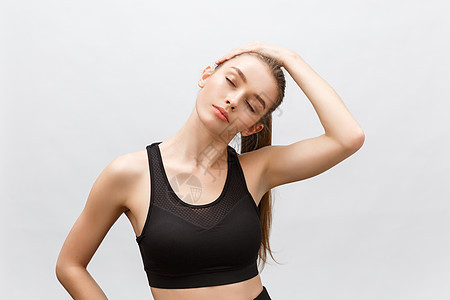 年轻运动的美丽美女肩膀伸着手臂 孤立在白种背景上健身房闲暇运动装裤子身体女士有氧运动训练瑜伽赛跑者图片