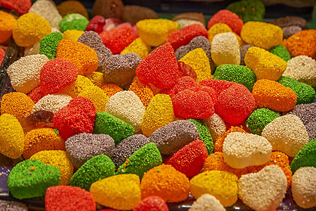 很多有糖和香味水果的多彩甜食 横向观景市场店铺甜点乐趣涂层糖果彩虹食物小吃橙子图片