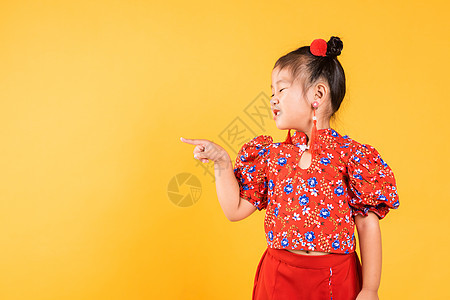 亚裔快乐的中国小女孩穿红色长相齐宝 指着太空女士节日手势戏服商业裙子微笑衣服女孩文化图片