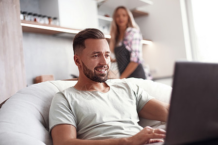 年轻家庭在厨房里闲暇时间夫妻网络互联网快乐上网男性计算技术幸福妻子图片