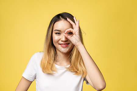 亚裔年轻女性手势良好 在黄色背景上被孤立女孩微笑商业成功人士女士工作室商务成人青年图片