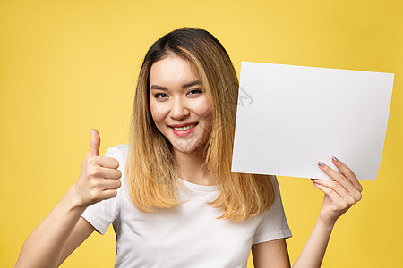 有吸引力的年轻美丽的亚洲女学生 拿着空白白纸 她很迷人海报木板推介会广告微笑成人卡片广告牌横幅女孩图片