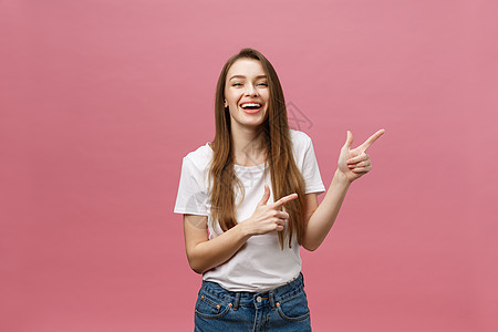 女性用手指对着相机和牙齿微笑 表达情感和感情概念 工作室拍摄 在粉红色背景上被孤立惊喜女士震惊快乐成人手势白色蓝色头发商业图片
