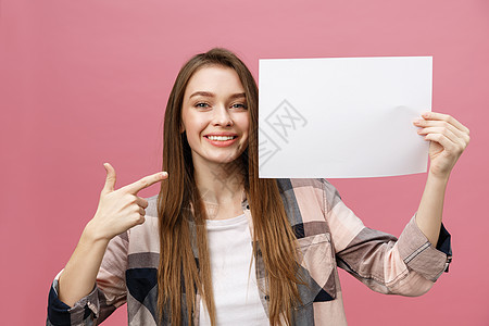 微笑的年轻女人站在一个空白板上指着她的手指广告牌工作室成人卡片海报商业青少年木板黑发广告图片