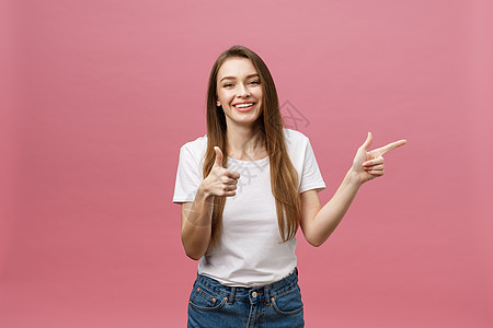 照片中快乐的年轻女性站在粉红色背景上 并用手指摸着她的手指学生时尚女孩工作室手势幸福青少年黑发女士商业图片