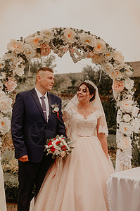 婚礼的仪式 背景 一个花朵拱门笑着接吻夫妻幸福裙子女性花束玫瑰女士男人庆典订婚图片