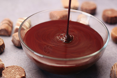 黑巧克力奶油倒在桌上的碗里图片