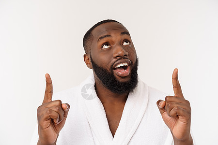 穿着浴袍的黑人用惊喜和快乐的情感指着手指 被排挤在长发背景上爆炸头巾白布房间白色幸福男性头发卷发反思图片