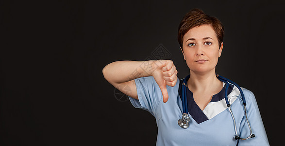 冷落的女医生 显示不赞成手持牌拇指向下破产专家医师女士失败职业保健护士卫生数字背景图片