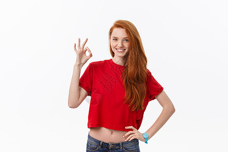 一个穿红色圣达克萨斯礼服的漂亮女人的肖像 展示了好的标志 并勾搭在白色背景上相机幸福女性成功微笑手指工作室女孩商业庆典图片