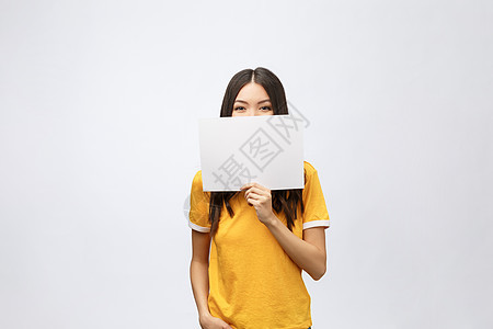 身穿黄衬衫 手握白标牌的奇异女孩被孤立快乐微笑成人人士惊喜广告牌商务木板空白卡片图片