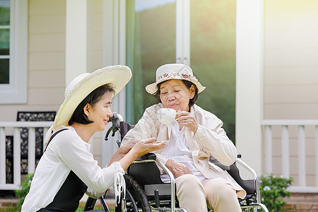 老年妇女与女儿一起在后院轮椅上放松卫生人士机动性家庭长老祖母病人父母退休帮助图片