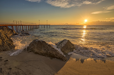 海面上升起 岩石上喷洒着海浪日出波浪阳光海景海洋太阳支撑反射海滩石头图片