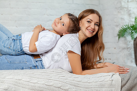 一个美丽的母亲的室内肖像 和她迷人的小女儿在卧室里摆着反面的姿势母性妈妈成人幸福家庭寝具童年孩子女孩女郎图片