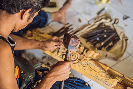 木雕大师使用一种特殊的刀具制作的木制国菜  带图案手柄的长柄勺 他手部特写的片段领班工程师工具男人工作盘子手工木匠活动胡须图片