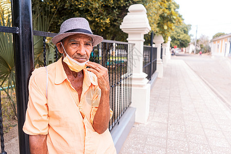 在街上脱下医疗面具时戴帽子 没有胡子的拉丁美洲老人图片