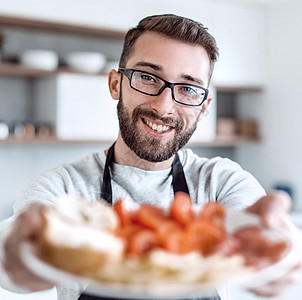 一个有魅力的男人手里的三明治 夹在一个漂亮的男人手中火腿烹饪男性丈夫早餐营养围裙小吃公寓盘子图片