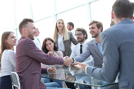 商业伙伴以握手方式互相互问候微笑生意人雇员办公室男性会议男人合伙桌子团队图片