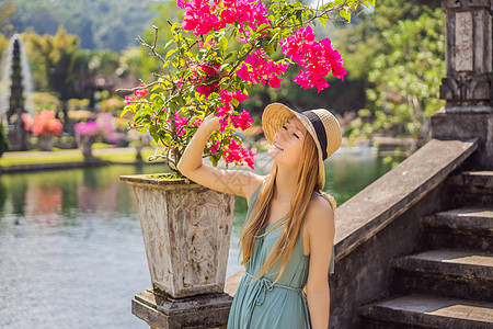 在印度尼西亚巴厘岛 水宫殿 水公园旅游的年轻妇女池塘热带情调地标反射喷泉异国花园纪念碑锦鲤图片