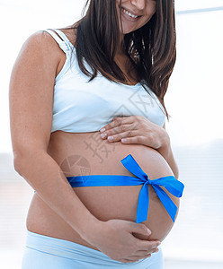 快乐的孕妇测量她的肚子和腰部图片