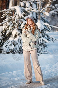 一个模范女孩在雪覆盖的森林中行走 展示着衣服帽子成人外套季节模型女士外观乐趣陈列室毛衣图片