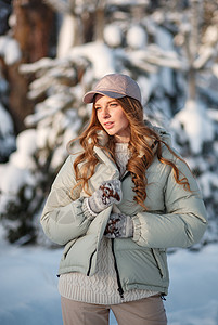 一个模范女孩在雪覆盖的森林中行走 展示着衣服手套模型乐趣女士喜悦松林季节女性成人雪花图片