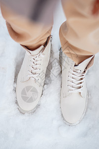 该模型展示了站在雪中站立的女鞋蕾丝靴子运动女士天气远足踪迹冒险鞋类脚步图片