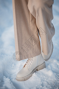 该模型展示了站在雪中站立的女鞋皮革冒险衣服运动天气脚步生活远足脚印蕾丝图片