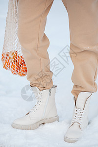 该模型展示了站在雪中站立的女鞋衣服女士天气鞋类运动冒险靴子蕾丝生活皮革图片