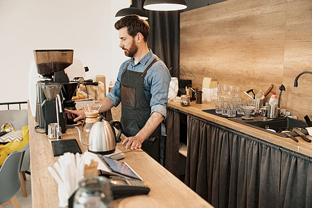 英俊的咖啡师在咖啡机中种植咖啡豆工作男人咖啡店铺成人饮料棍棒商业调酒师酒吧图片