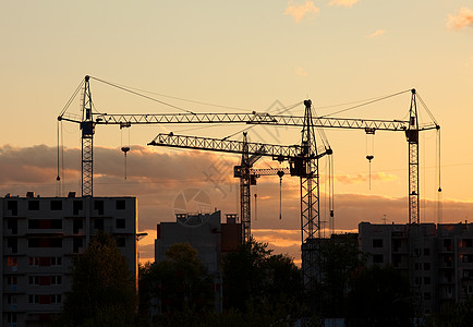 日落时建筑工地房屋起重机图片