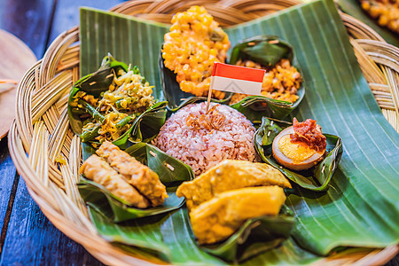 Nasi lemak Nasi campur 印度尼西亚巴厘岛米饭配土豆油条 沙爹百合 炸豆腐 辣煮鸡蛋和花生马来语美食蔬菜雄鸡图片