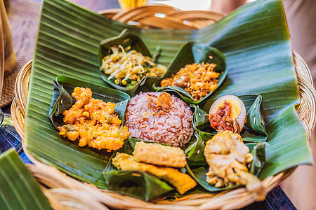 Nasi lemak Nasi campur 印度尼西亚巴厘岛米饭配土豆油条 沙爹百合 炸豆腐 辣煮鸡蛋和花生豆腐厨房雄鸡美食叶图片