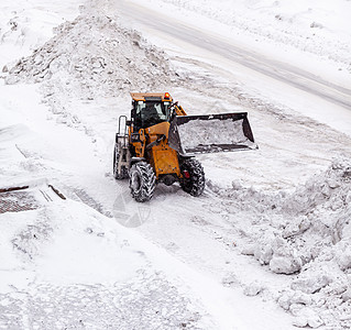 清扫和清理城市道路 以摆脱冬季的积雪刮刀降雪卡车推土机装载机运输街道行动车辆工作图片