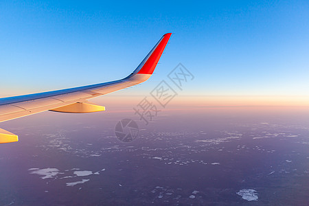 飞机的机翼和地面通过照明器观察到 在空中飞行高度运动航空小翼商业翅膀日落乘客速度旅行图片