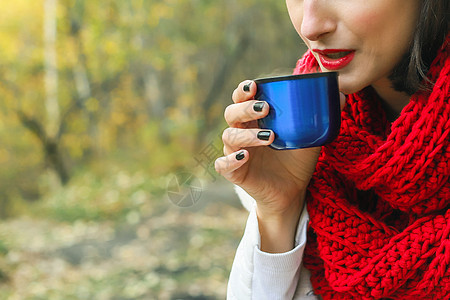 穿着白色大衣 围巾和黑帽子的女人手里握着杯子 自然而然的茶会图片