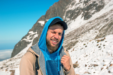 一个留胡子的男人在山坡上微笑 雪地顶图片