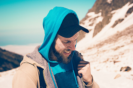 一个在雪山脚边留胡子的男人 头上戴着黑帽图片