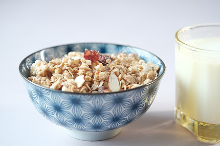 家里在碗里做的穆斯利 一碗牛奶和餐桌上的面包榛子椰子燕麦粮食杏仁谷物葡萄干乳制品浆果营养图片