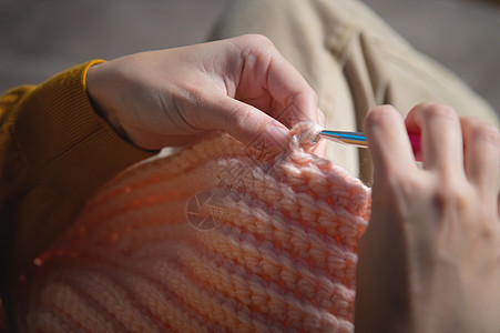 亲手贴近女性的手 在家中沙发上编织衣服 手工制作羊毛针织品爱好材料时尚女士钩针编织者手指女孩图片