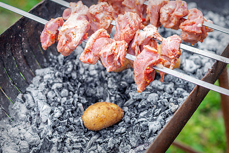 男人准备烧烤肉和土豆火盆烤串野餐厨师烹饪餐厅食物午餐厨房煤炭图片