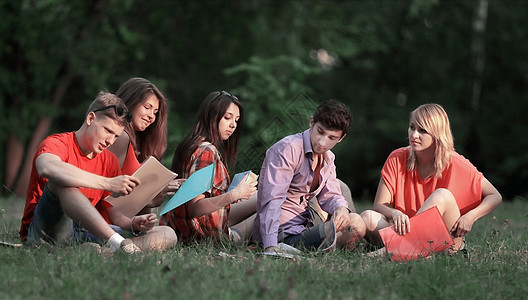 一群坐在公园草地上的朋友学生团体成员图片