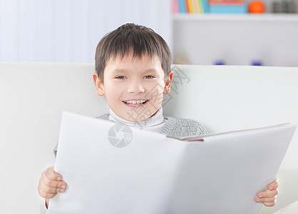男孩在托儿所读书时笑着笑着看书图片