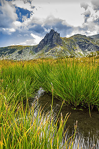 山上有青草 水和山丘的美景全景戏剧性高山公园风景旅行植物旅游冒险爬坡图片