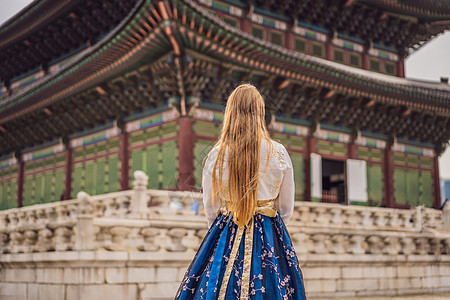 在韩国宫殿穿着韩服的年轻白人女游客 前往韩国的概念 韩国民族服装 游客娱乐试穿韩国民族服饰街道国家女士女性传统建筑学城市旅行文化图片