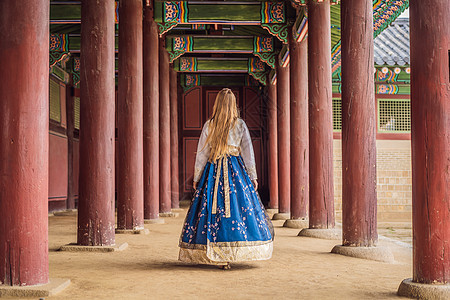 在韩国宫殿穿着韩服的年轻白人女游客 前往韩国的概念 韩国民族服装 游客娱乐试穿韩国民族服饰历史文化地标女孩花园蓝色建筑学裙子城堡图片